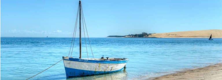 Sailing boat near to the beach with dunes in the background in Mozambique