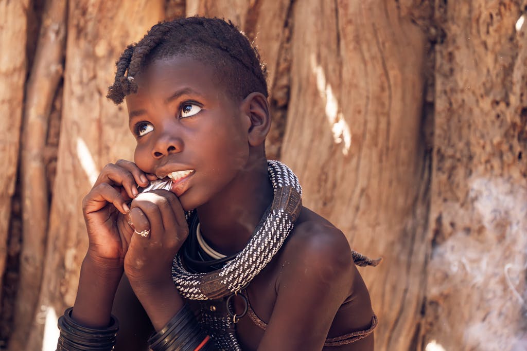 A thoughtful child with traditional attire reflects cultural heritage.
