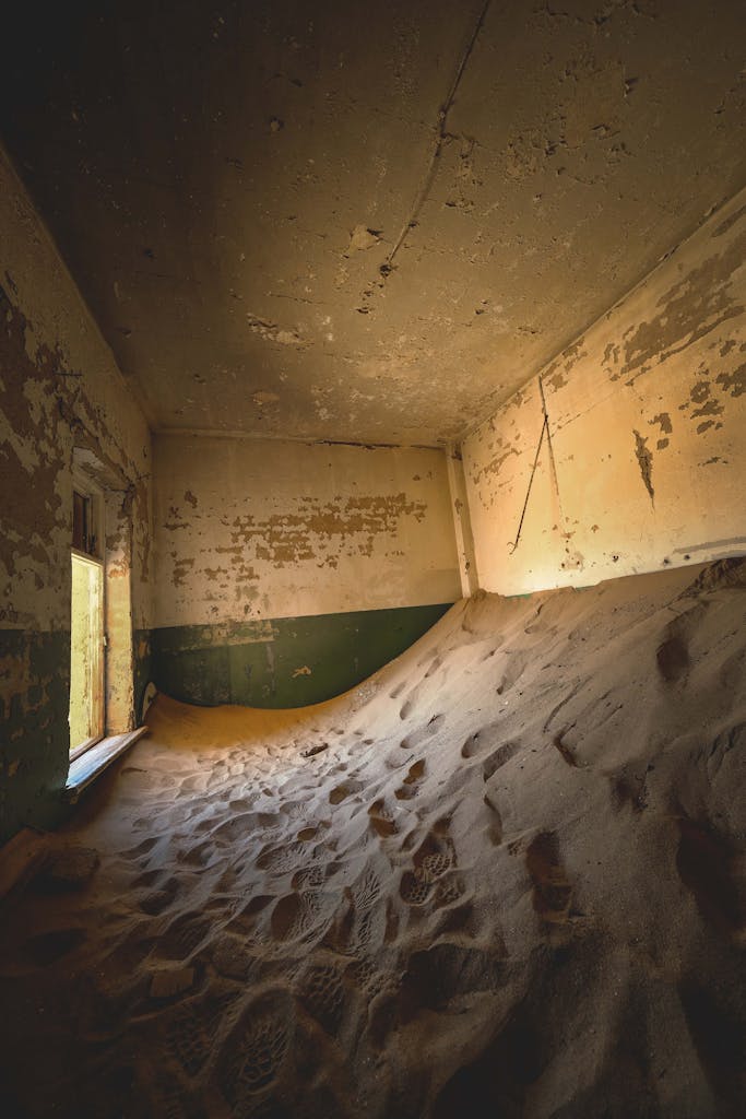 19 Day - Ultimate Namibia Tour 1 Explore the haunting beauty of an abandoned sand-filled room in Kolmanskop, Namibia.