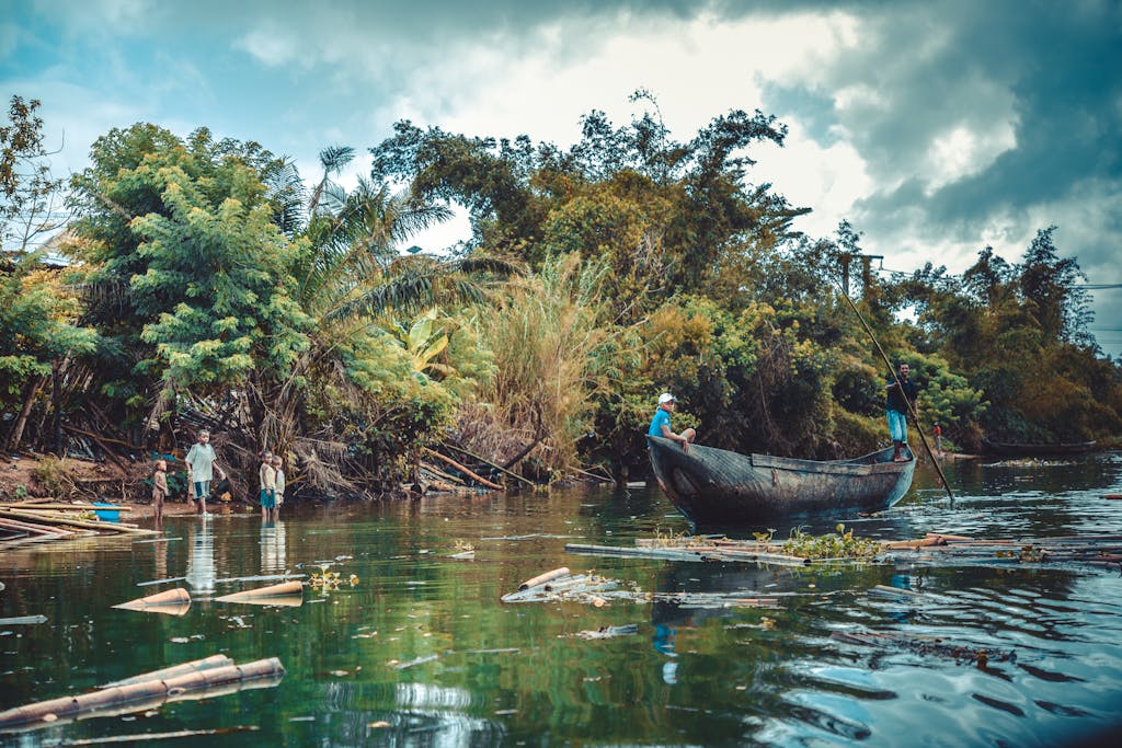 12 Day Madagascar Small Group Tour 2 Scenic view of people boating on a lush river surrounded by vibrant greenery in Madagascar.